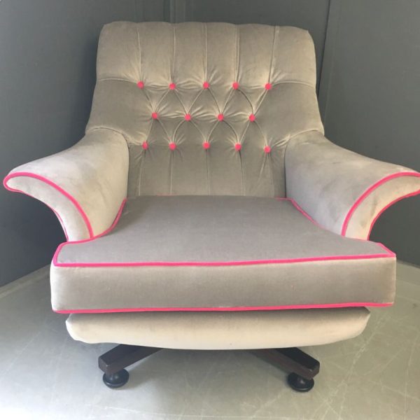 Reupholstered grey velvet chair with hot pink buttons and piping on a swivel base